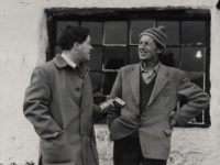 Two people standing in front of buildings