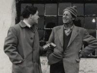 Two people standing in front of buildings