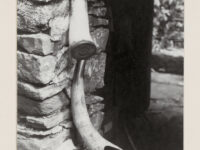 Two medicine horns hanging off a stone wall.