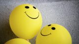 yellow balloons with smiley faces drawn on them