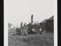 Children climbing on a pile of wood and discarded furniture which has been built up into a bonfire (unlit at this point), on wasteland in Dewsbury (West Yorkshire).