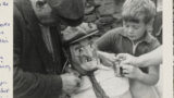 Mr. James Ward of West Witton ( Wensleydale) with a young boy, putting the finishing touches to the Bartle for the West Witton Bartle Fair.
