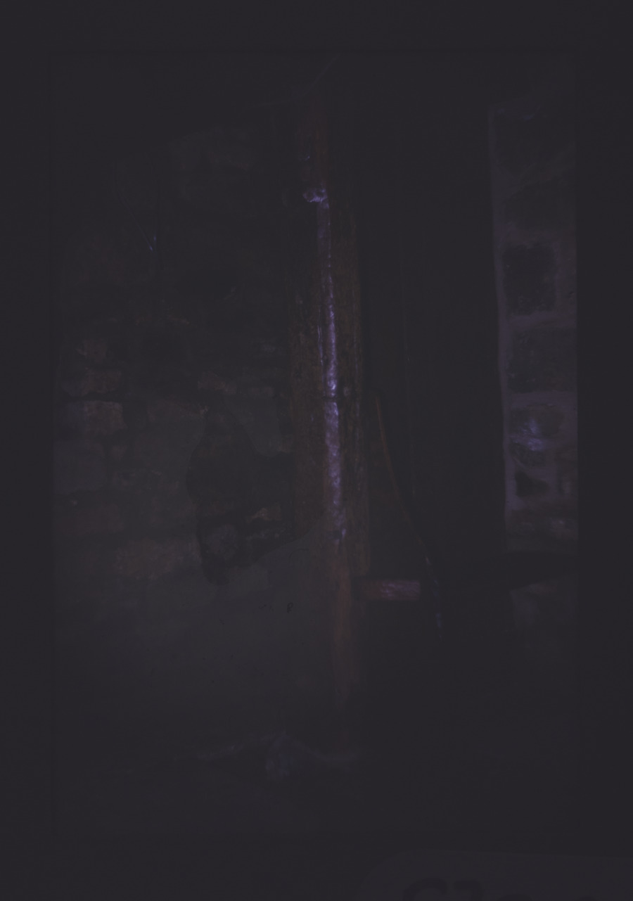 Wooden pole in dark barn.